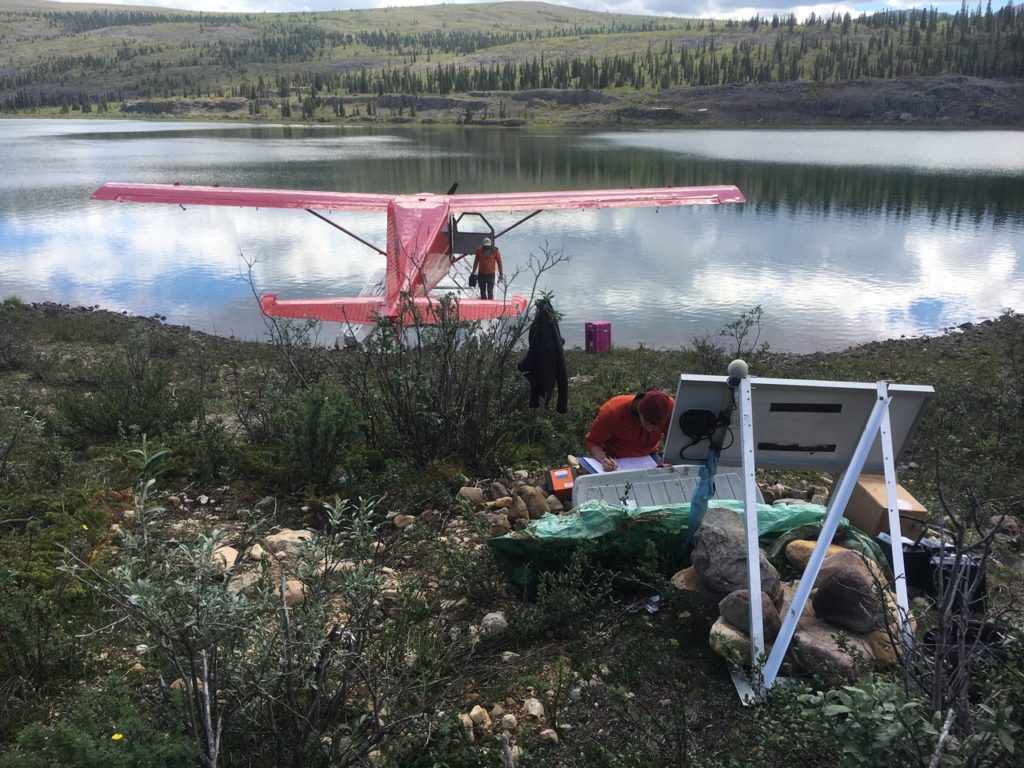 Two men working near an airplane parked on the water