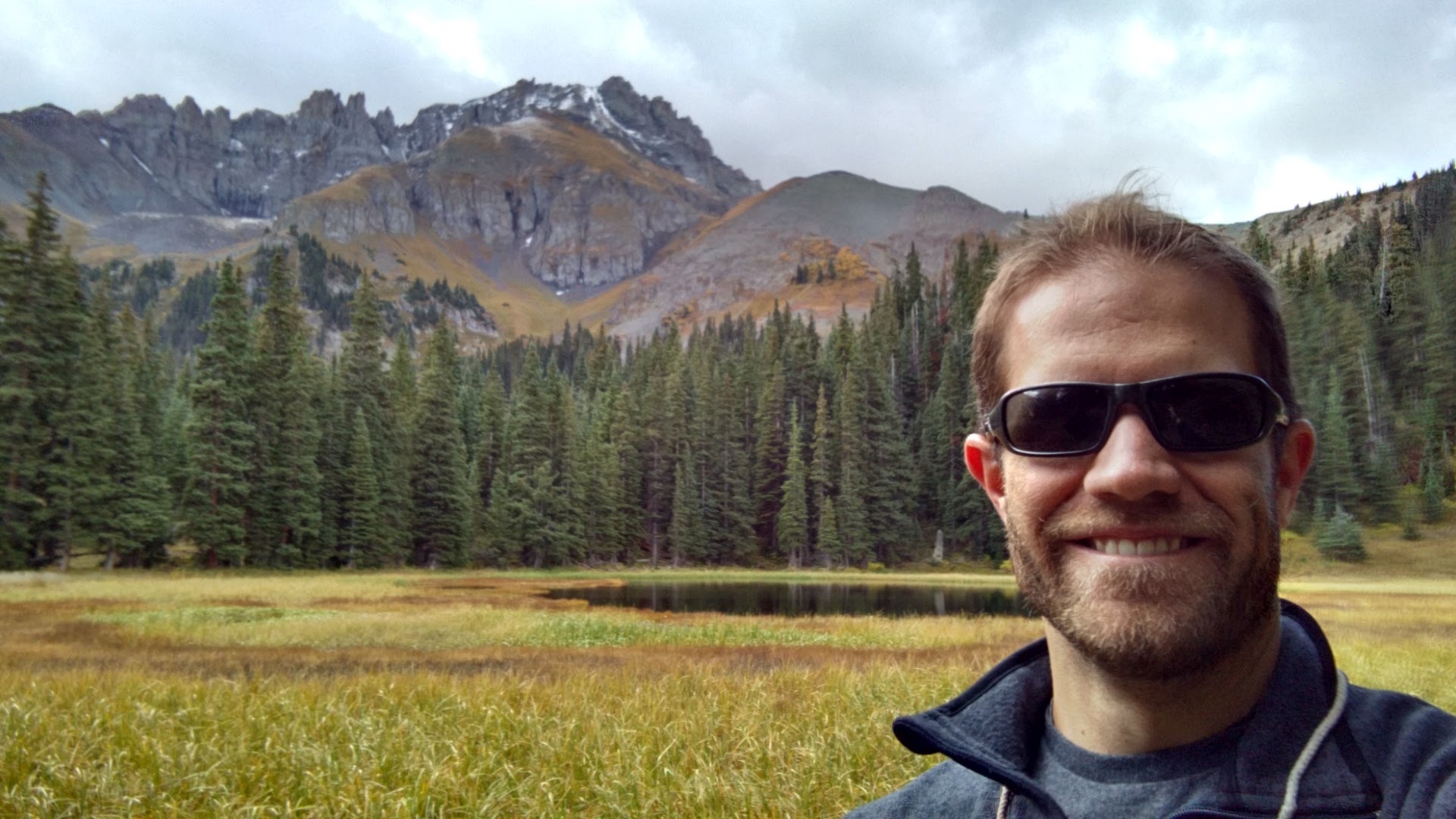 doctoral candidate in front of mountain and meadow