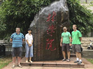 people in front of a rock with Chinese inscription