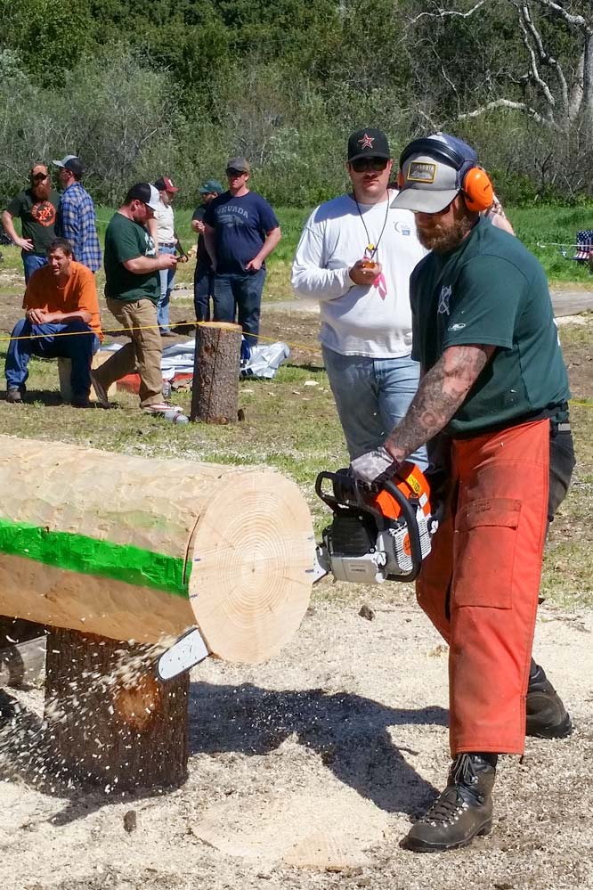 man cuts log with chainsaw
