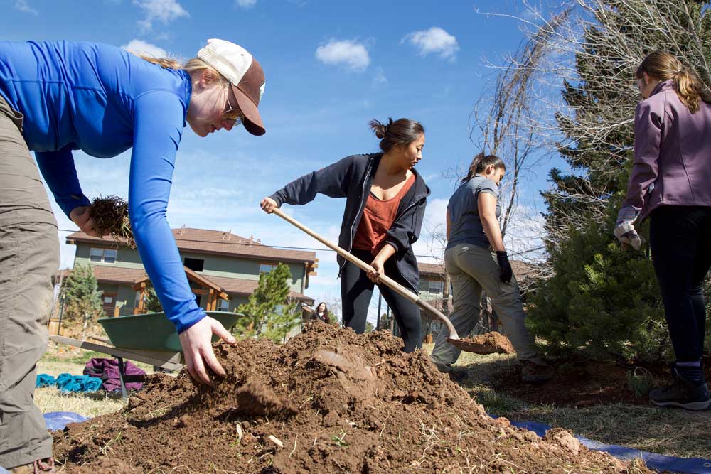 students shovel dirt