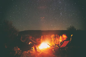 Camping under the stars in Colorado around a campfire.