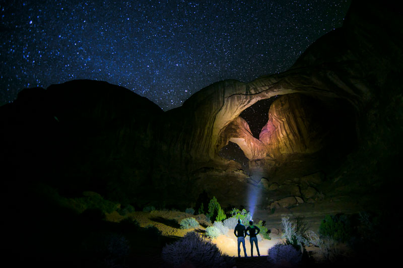 night sky over a lighted natural arch