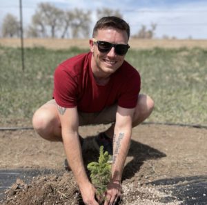 Nate Kettle plants a tree.