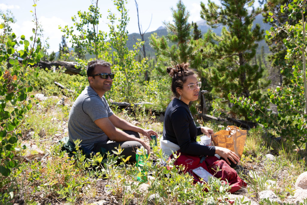 two people sit on a mountainside
