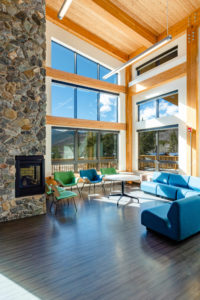 Chairs, couches, and a fireplace by windows overlooking Mummy Range