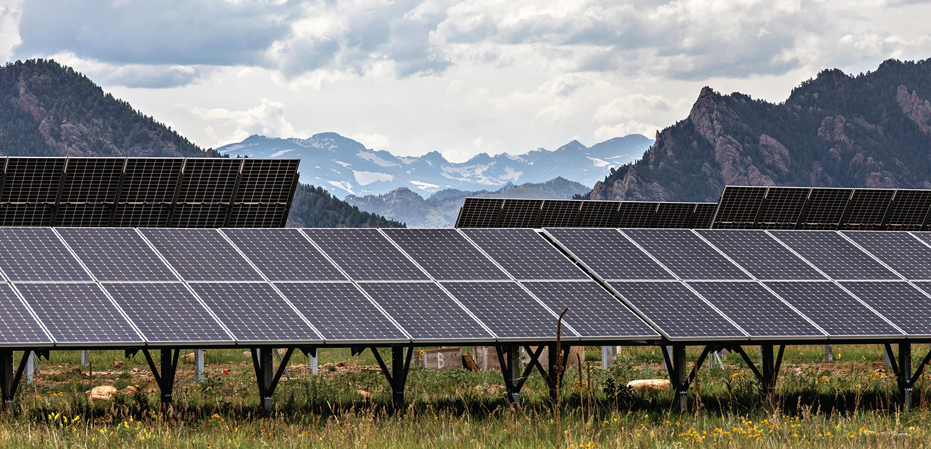 Solar panels in a field with mountain range in background